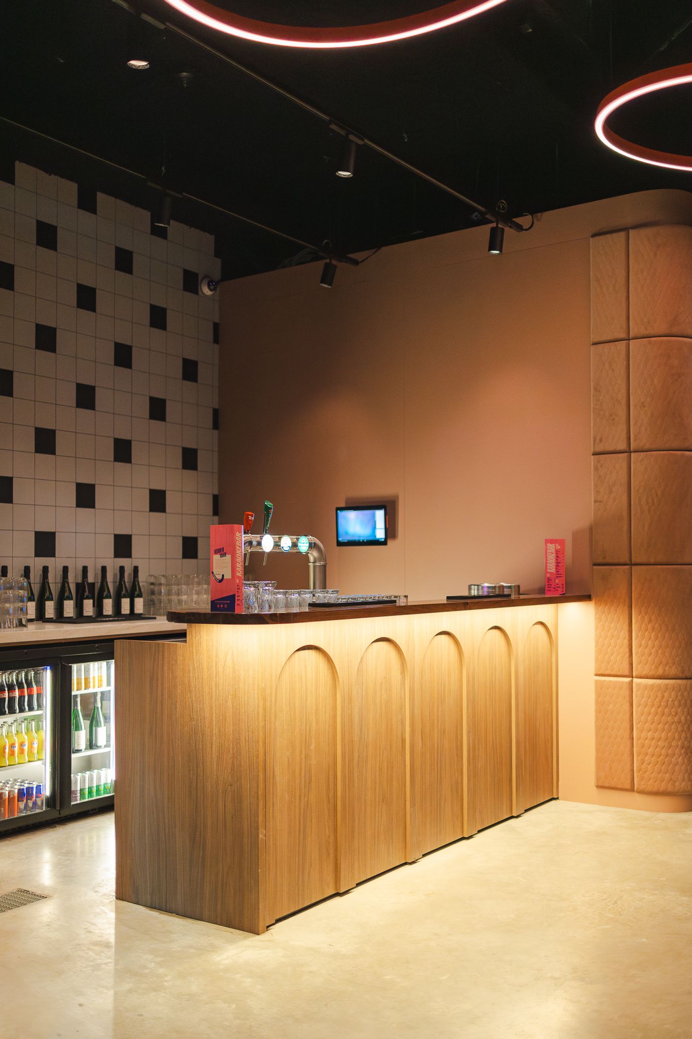 Modern interior hallway with wooden paneled walls, black ceiling, and illuminated display cases along the walls.