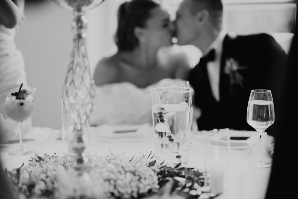 Romantic table setting with wine glasses and candlelight during wedding reception.