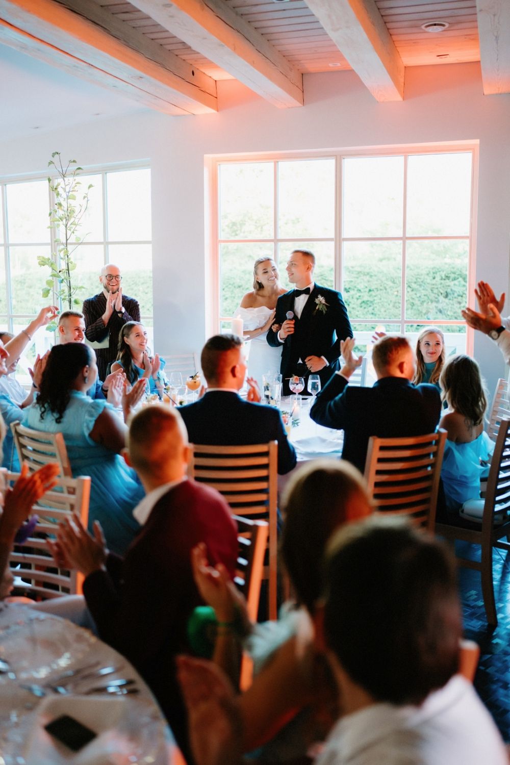 Wedding reception venue with guests applauding during celebration.