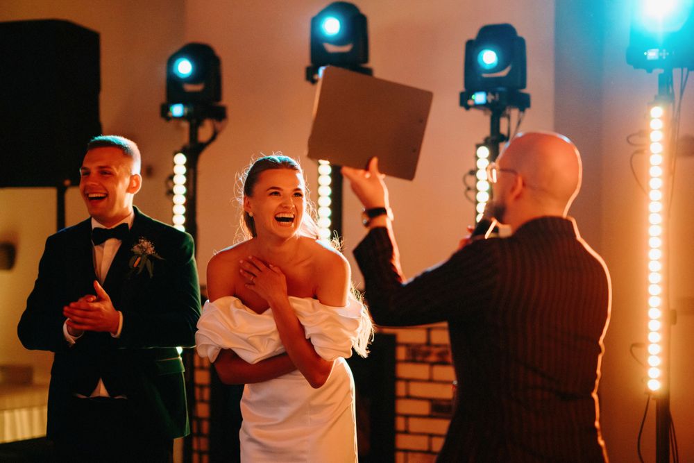 Guests dancing and celebrating at a wedding reception with blue uplighting creating an energetic atmosphere.