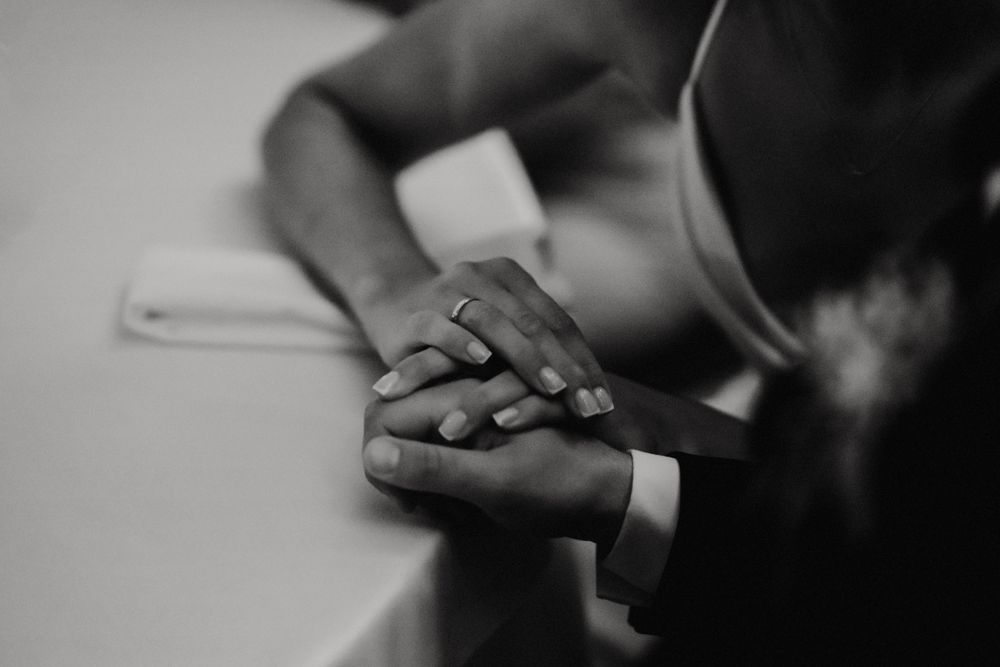 Monochrome close-up shot of hands holding drinks during a celebratory moment.