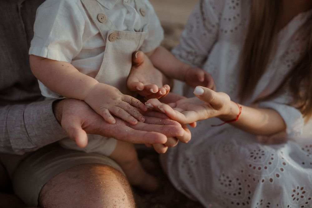 Close-up of hands clasped together in intimate gesture against soft light background.