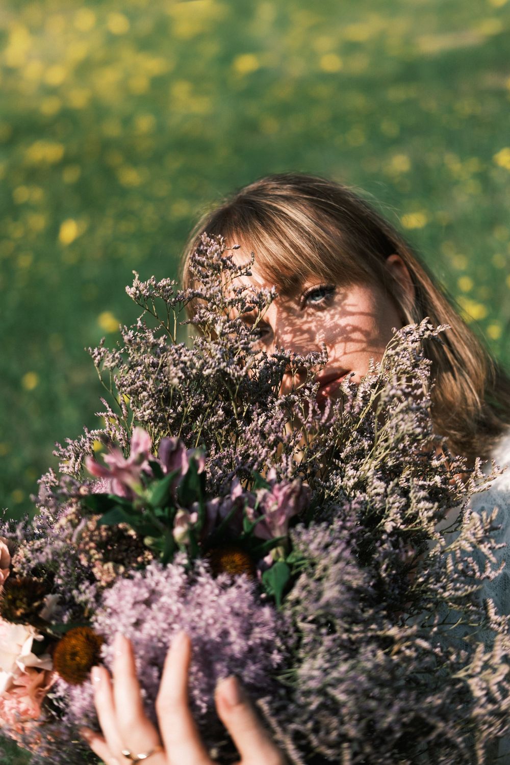 Natural branding portrait of a woman in a flower field holding a bouquet, captured as part of personal branding photography in Milan.