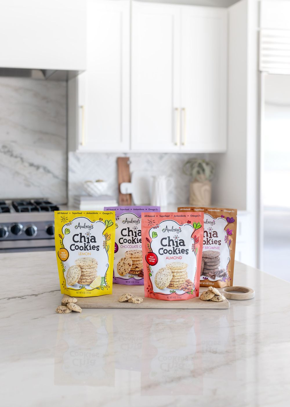Various flavors of Audrey's Chia Cookies displayed on a white kitchen counter.
