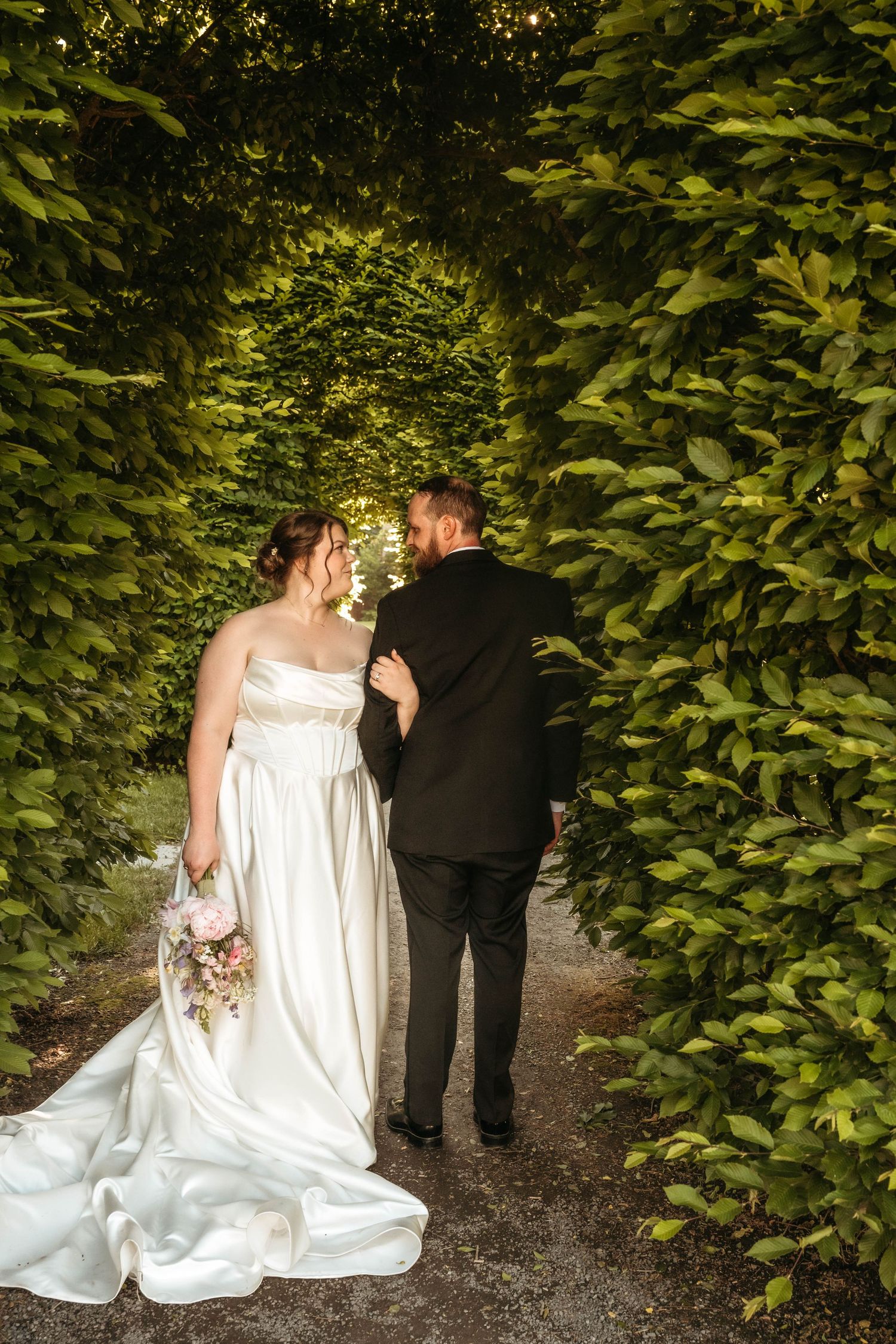 A romantic wedding moment captured in black and white between newlyweds in an orchard.