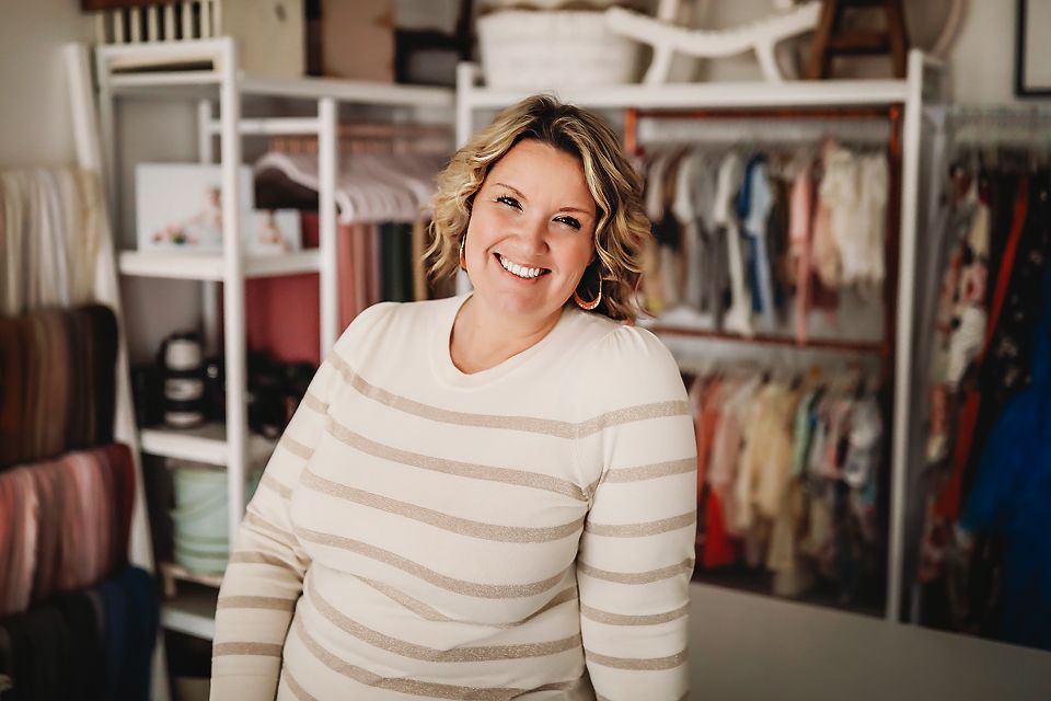 Woman in striped sweater smiling in indoor lifestyle setting.