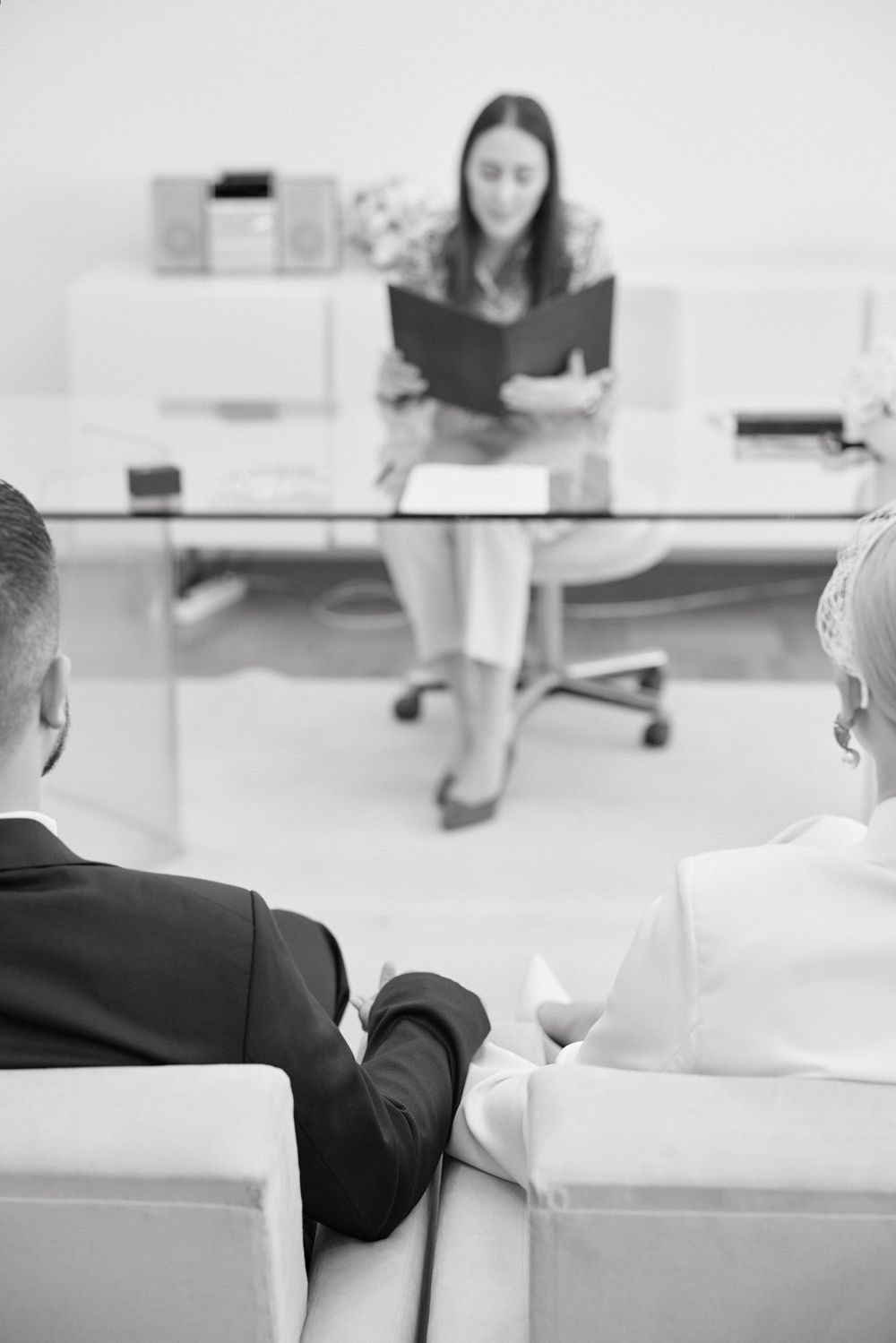 Business professionals seated in a row at a conference or meeting in a bright modern office setting.