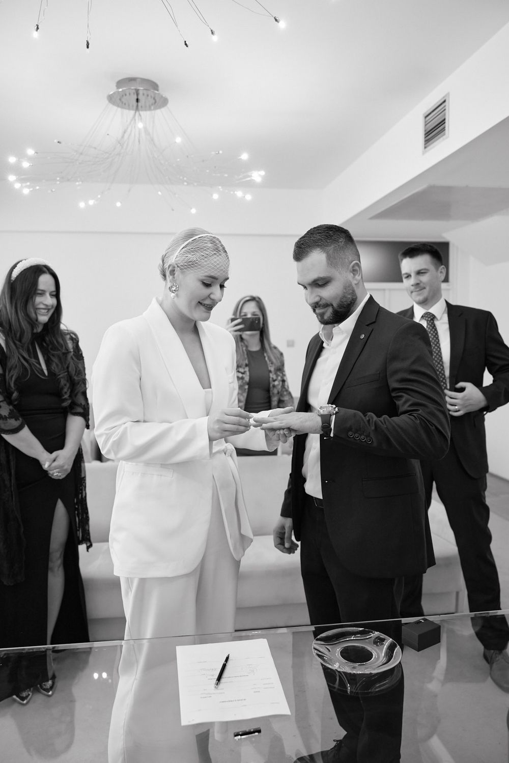 A group of people in formal attire sharing laughter and conversation at an indoor event.