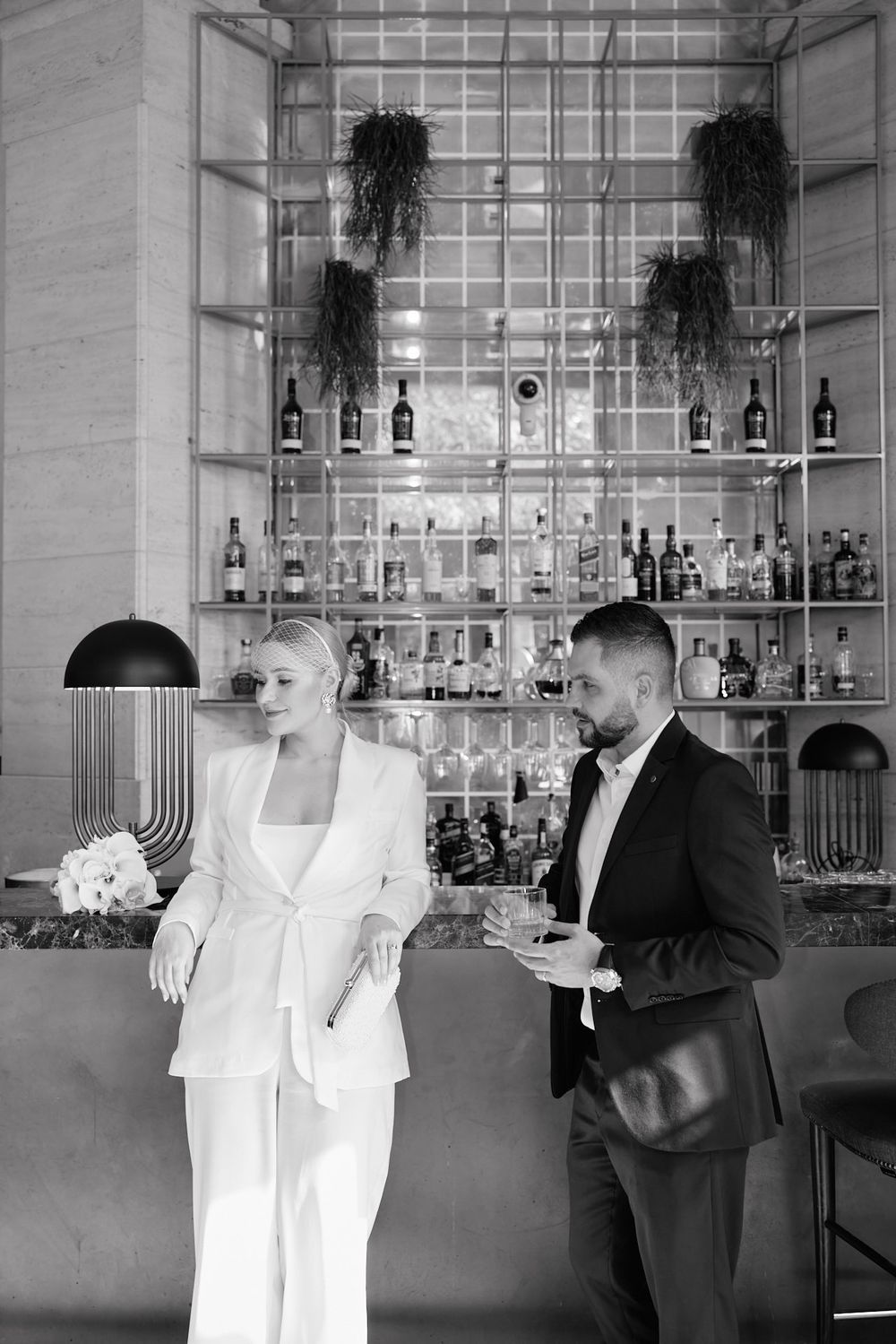 Wedding couple shares intimate moments in a series of black and white photographs at a contemporary bar setting.