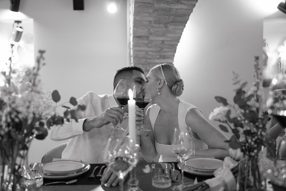 Intimate dinner reception scene with candlelit tables and decorative floral centerpieces.