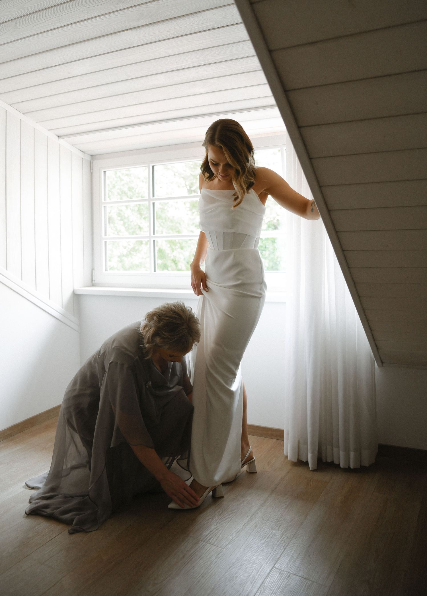 A sequence of intimate wedding preparation moments in a bright white attic room with wooden floors.