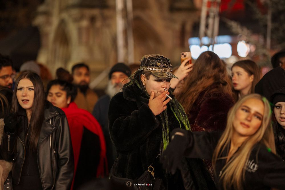 Crowd of people gathered at a dimly lit nighttime event or gathering.