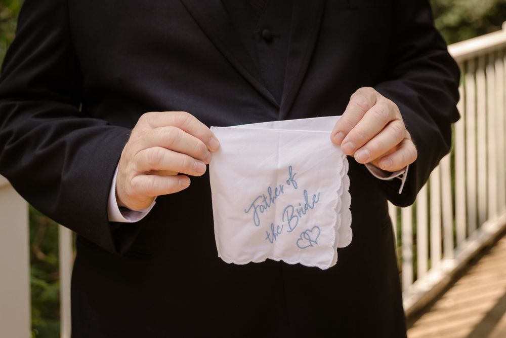 Close-up sequence of hands tearing paper into smaller pieces against a dark background.