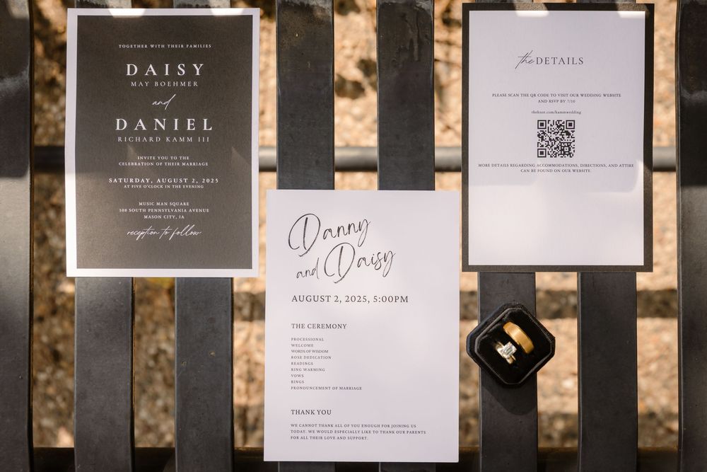 A collection of elegant black and white wedding invitations and menus displayed in a row against a dark background.