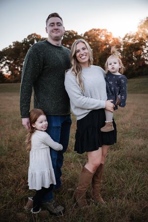 A family portrait in a field at golden hour wearing coordinated casual fall clothing in Stafford VA.