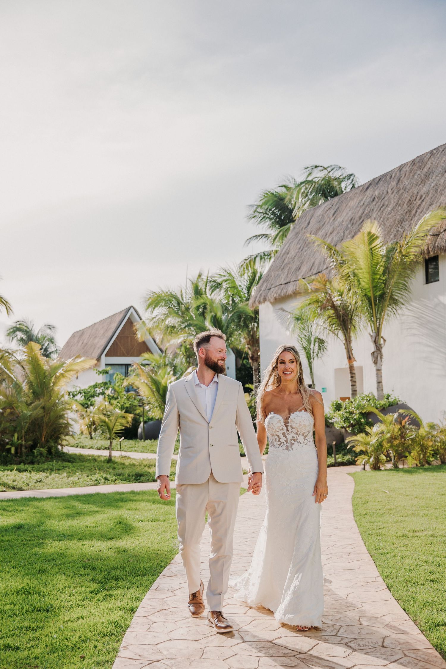 A couple walks hand in hand along a tropical resort Dreams Sapphire Riviera Maya Wedding Photography
