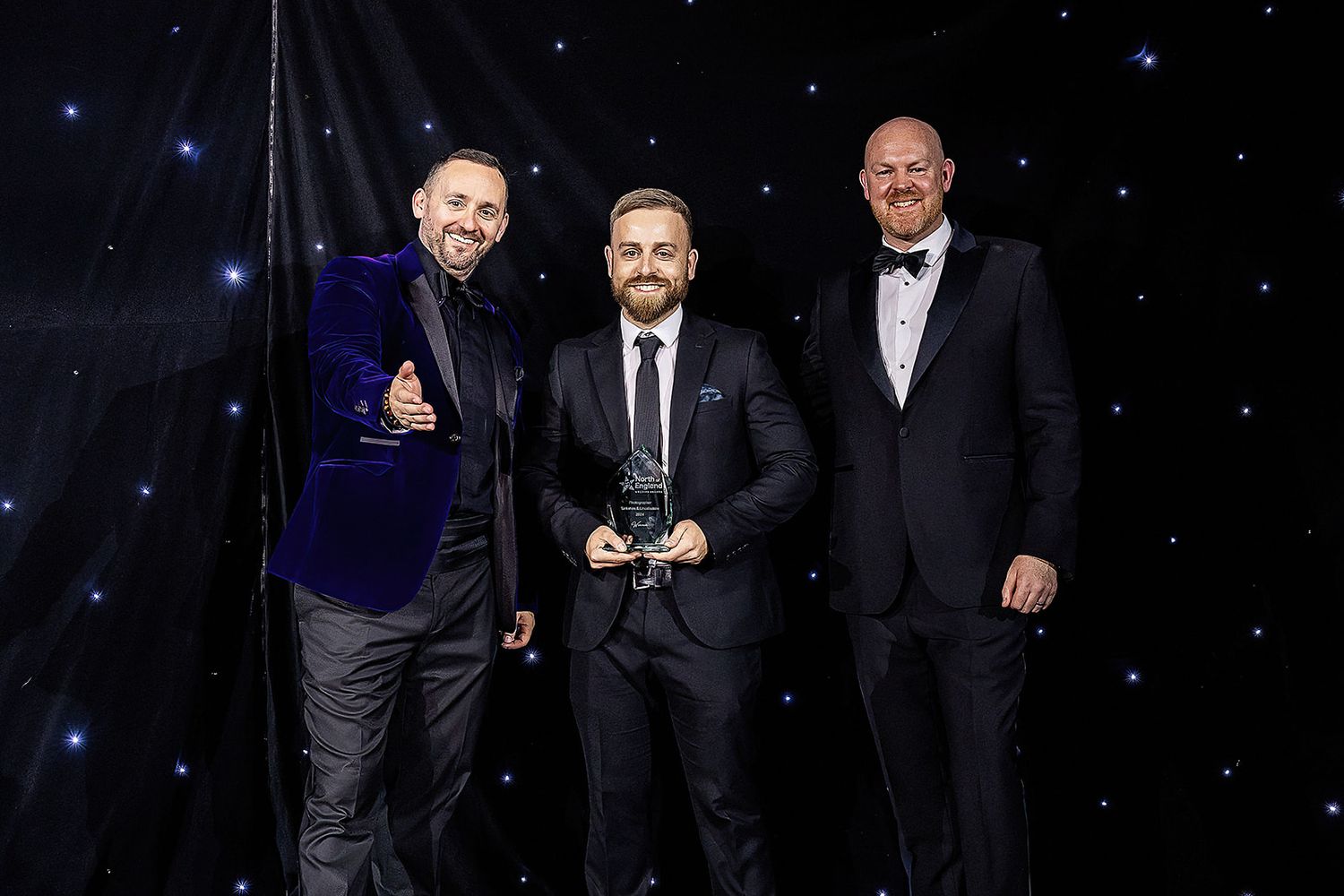 Award ceremony scene with formal attire against a starry backdrop.