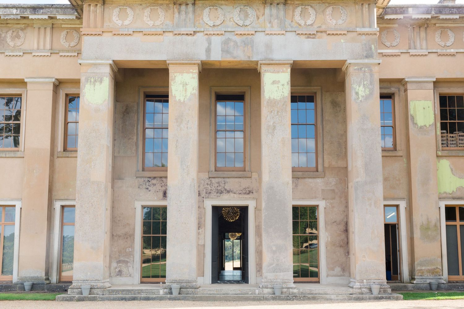 Ornate neoclassical building facade with tall stone columns and arched windows in a symmetrical design at The Grange Northington