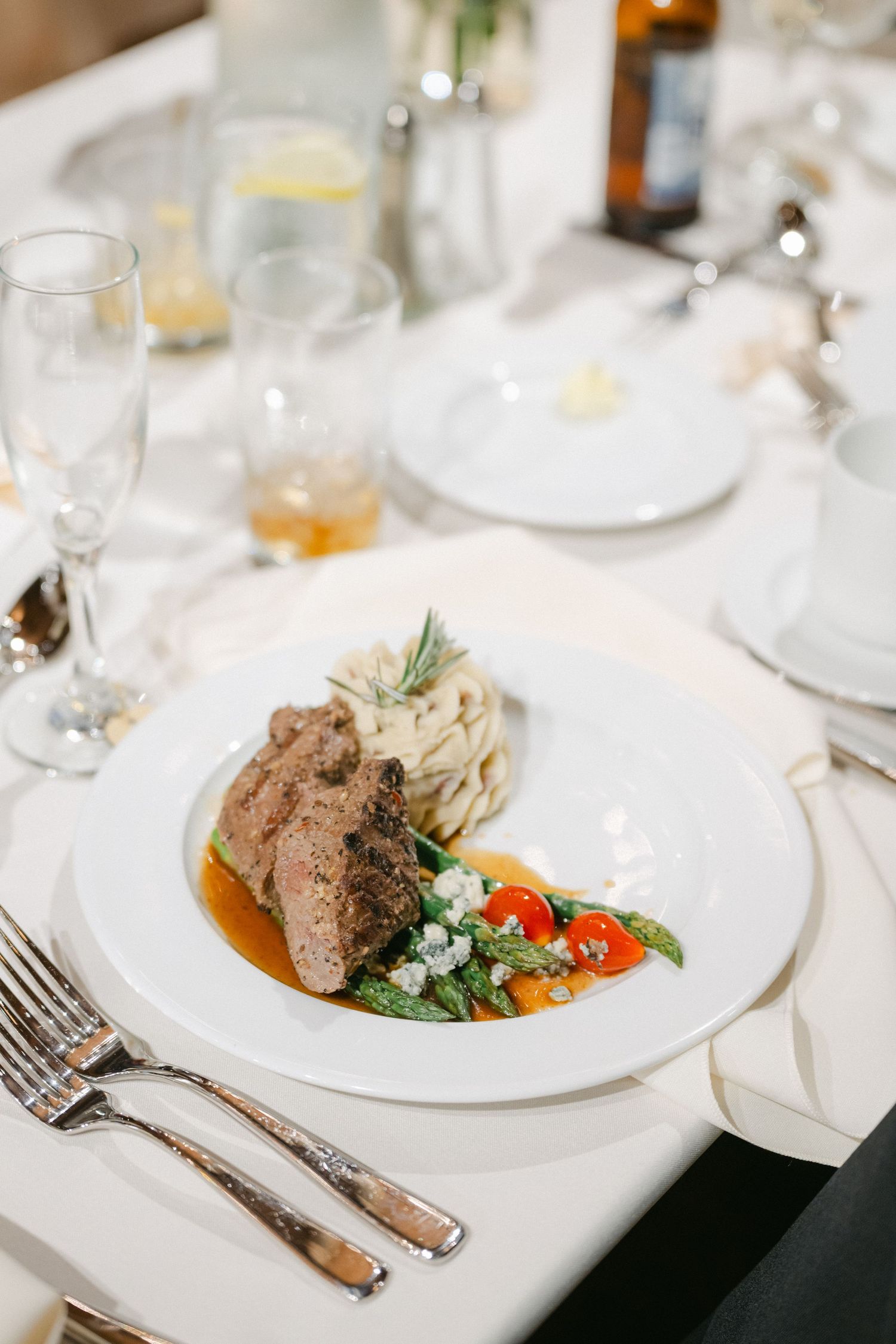 Elegant plated gourmet meals served on white dishes with garnishes at an upscale restaurant setting.