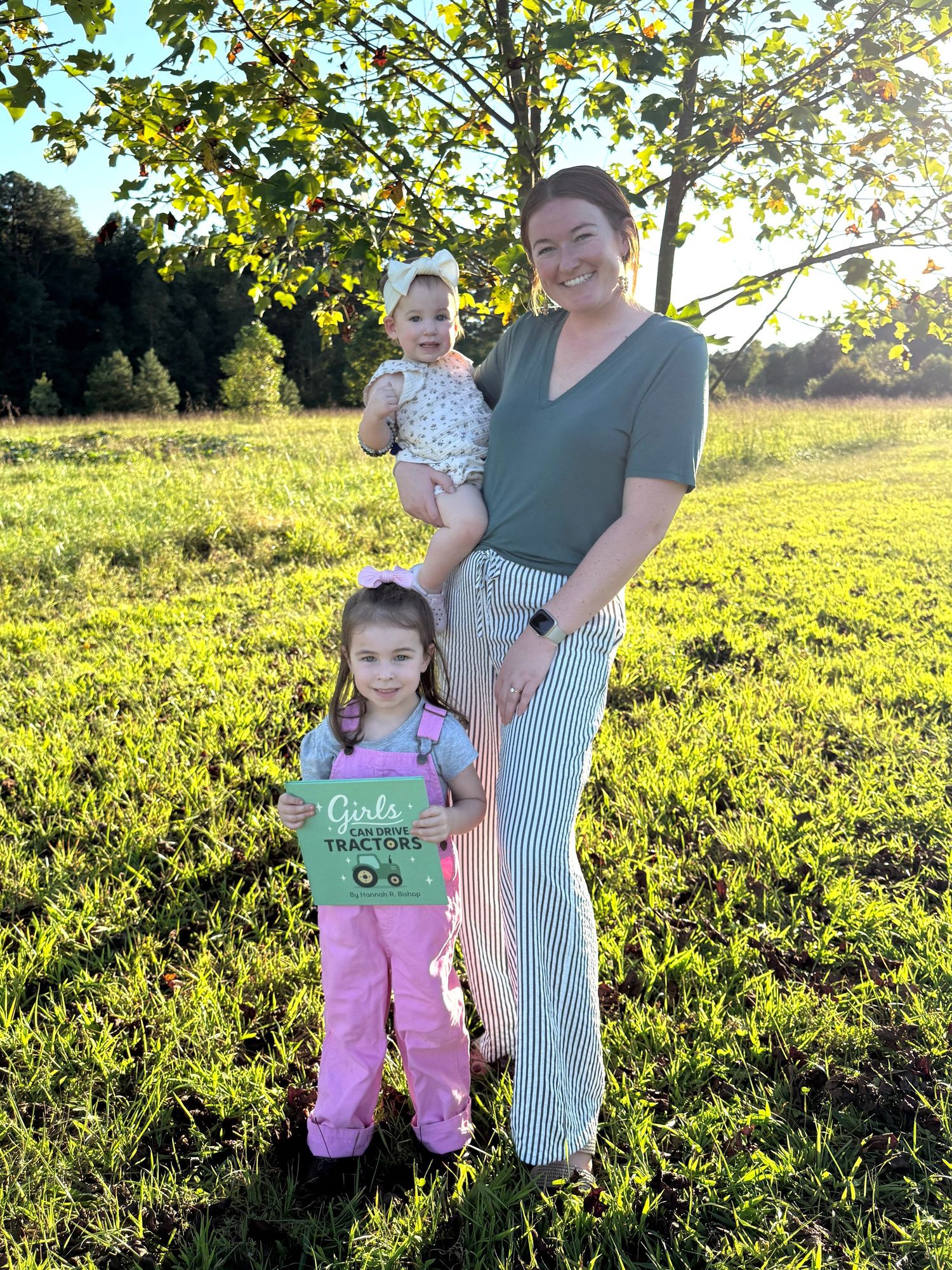 Family enjoying a sunset photo session in a golden field with tall grass and autumn foliage.