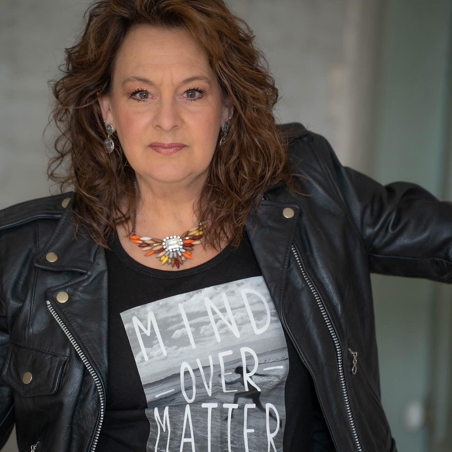 Black leather jacket styled with text overlay messaging in monochrome theme.
