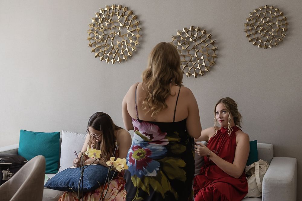 People sitting together on a couch sharing snacks and drinks during a casual gathering at home.