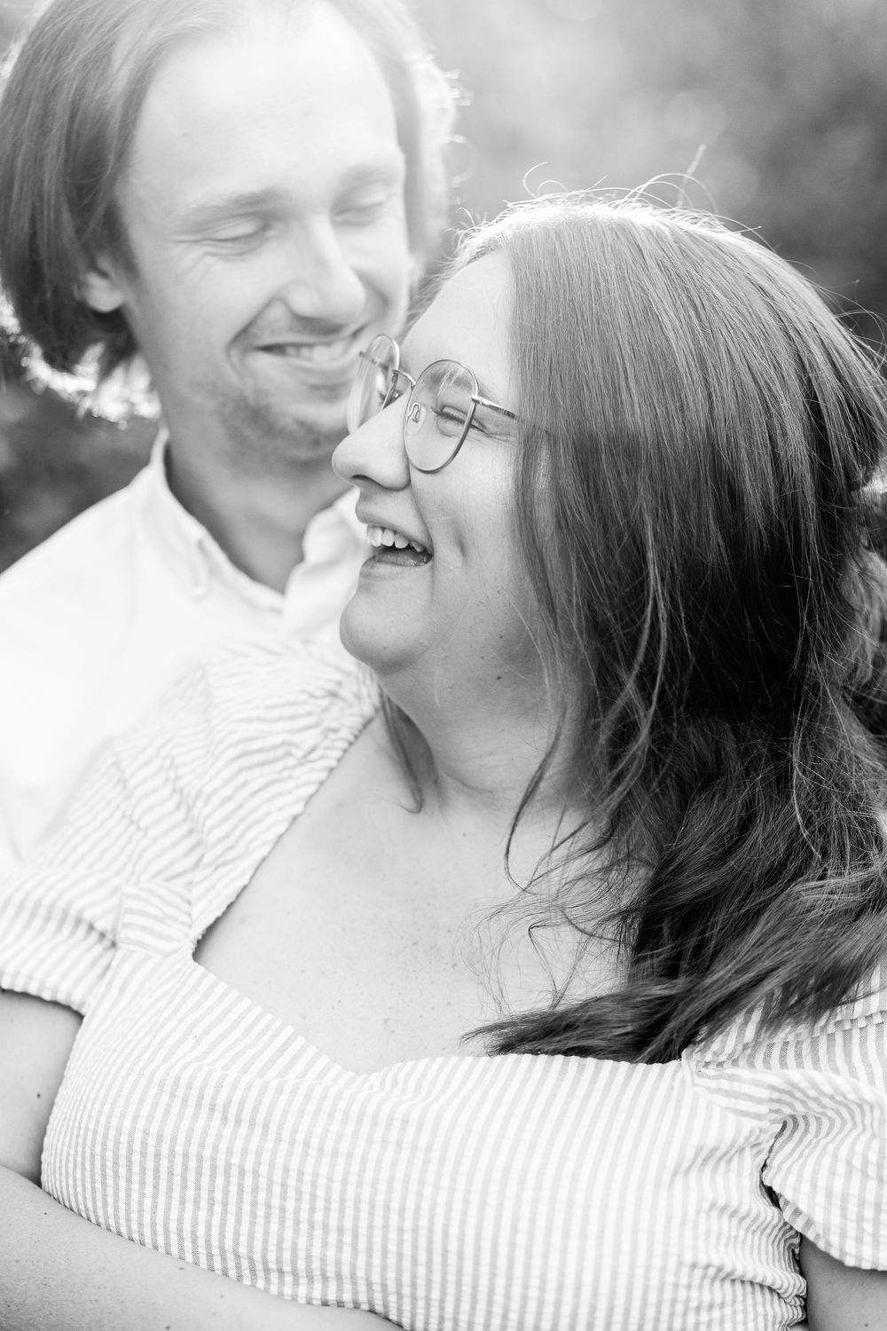 Black and white romantic photo series showing a couple laughing and embracing in intimate close-up shots.