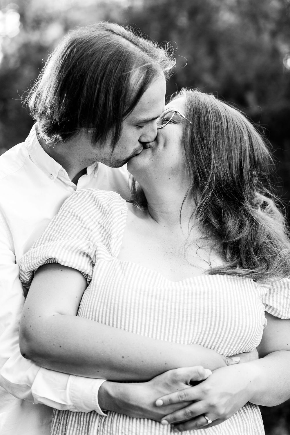 A romantic black and white photo series showing a couple embracing and kissing in an intimate sequence.
