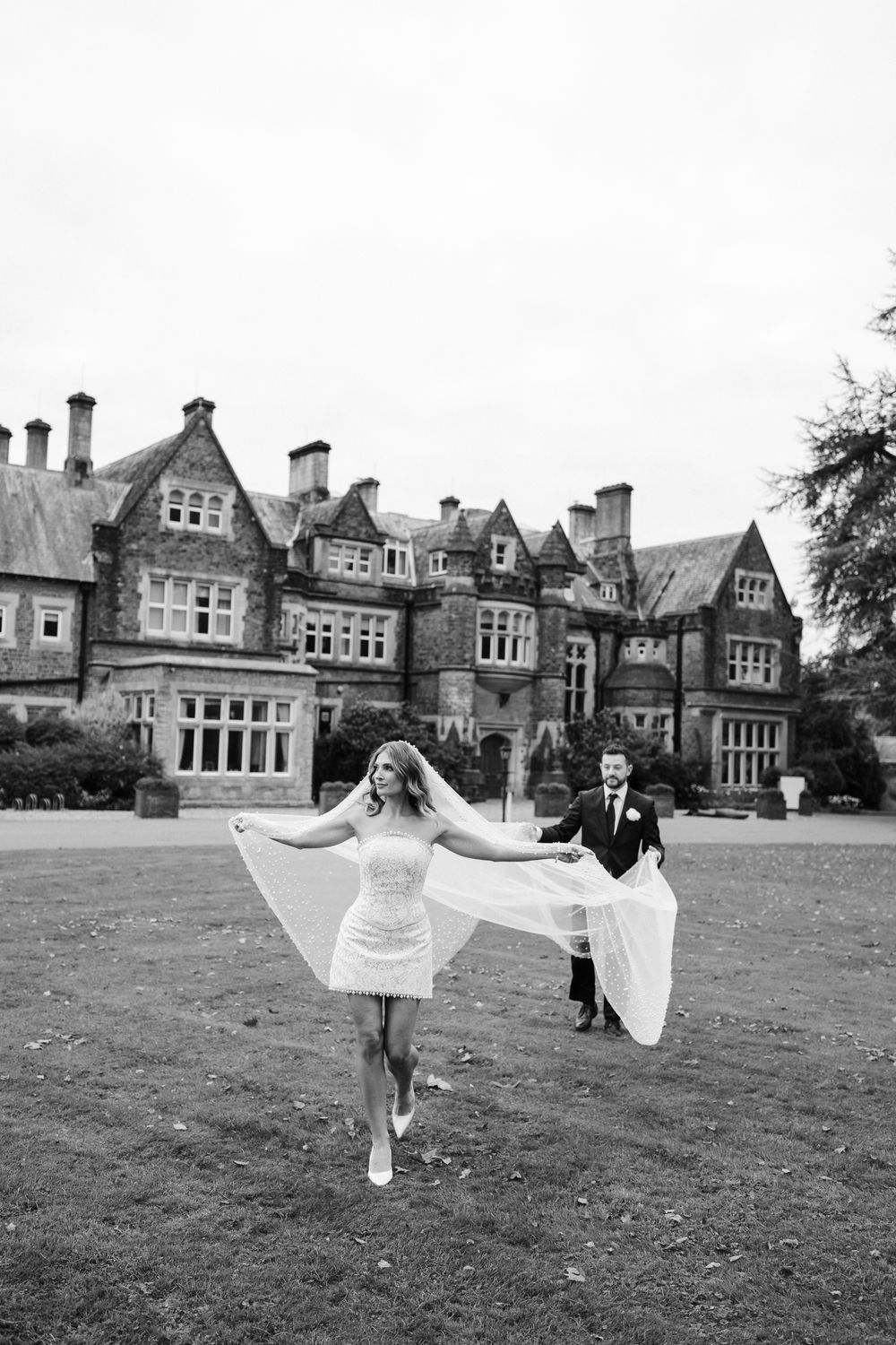 A sequence of black and white photos showing a couple dancing and spinning on a grand manor house lawn.