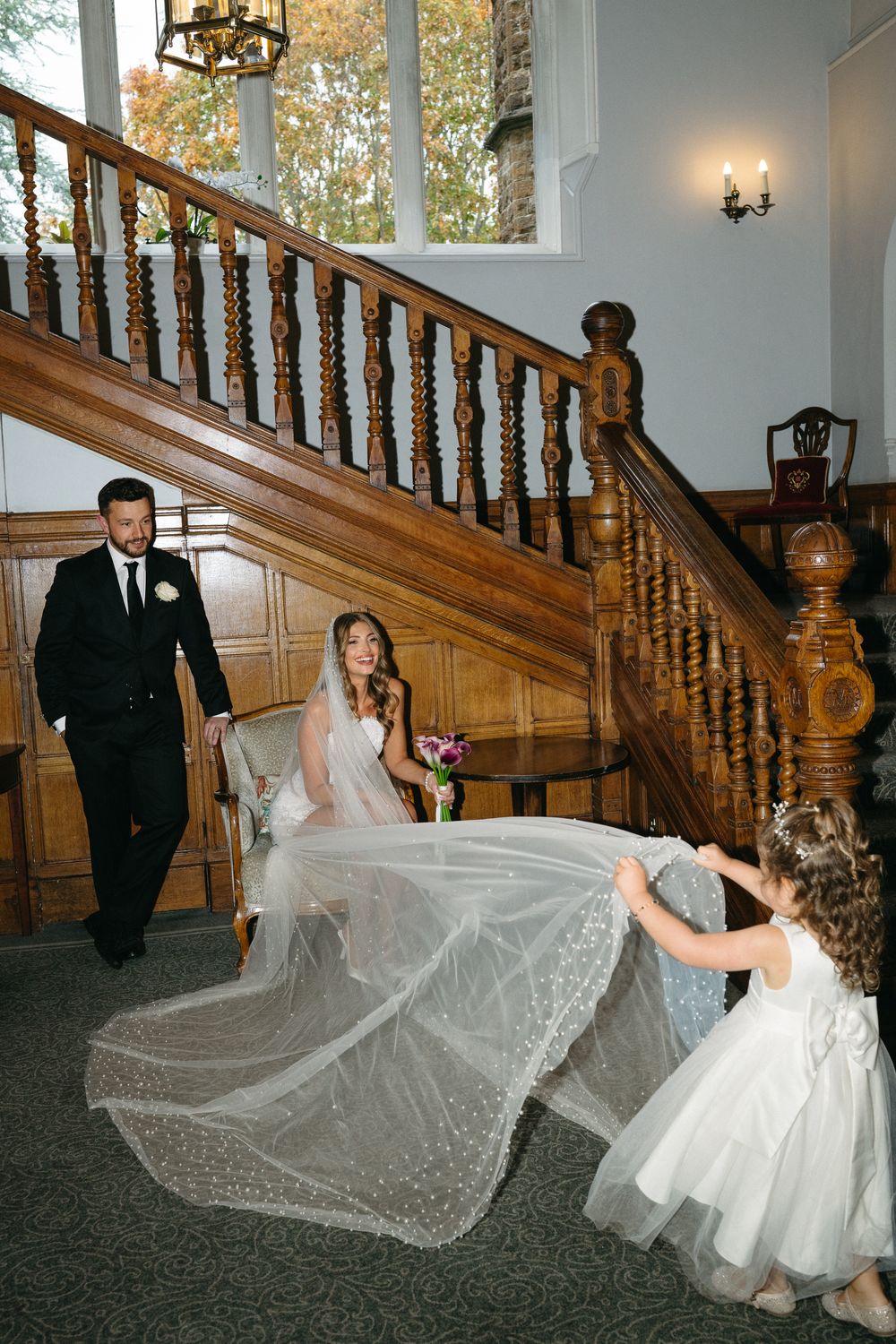 A sequence of photos showing a bride's veil flowing dramatically on an elegant wooden staircase in an indoor setting.