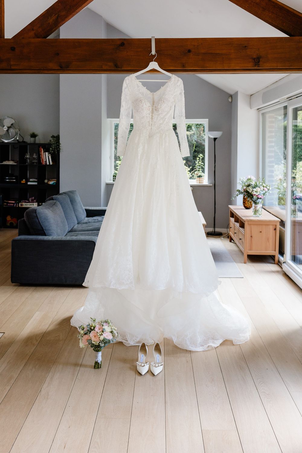 Robe de mariee pronovias avec details des fleurs et des chaussures lors des preparatifs de la mariee pres de Lille avant l'eglise