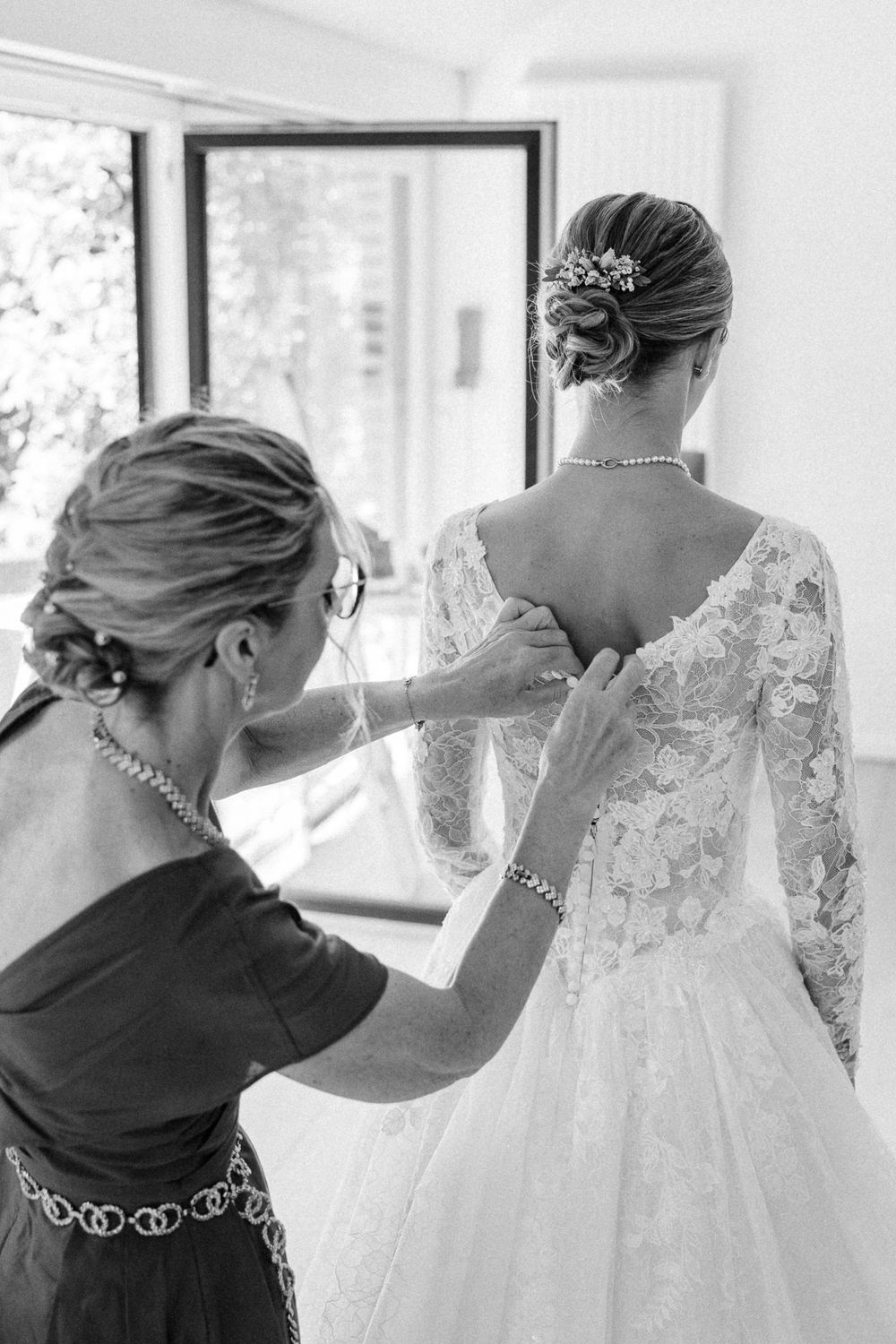Reportage mariage professionnel : la mere de la mariee ajuste sa robe avant la ceremonie a Lambersart.