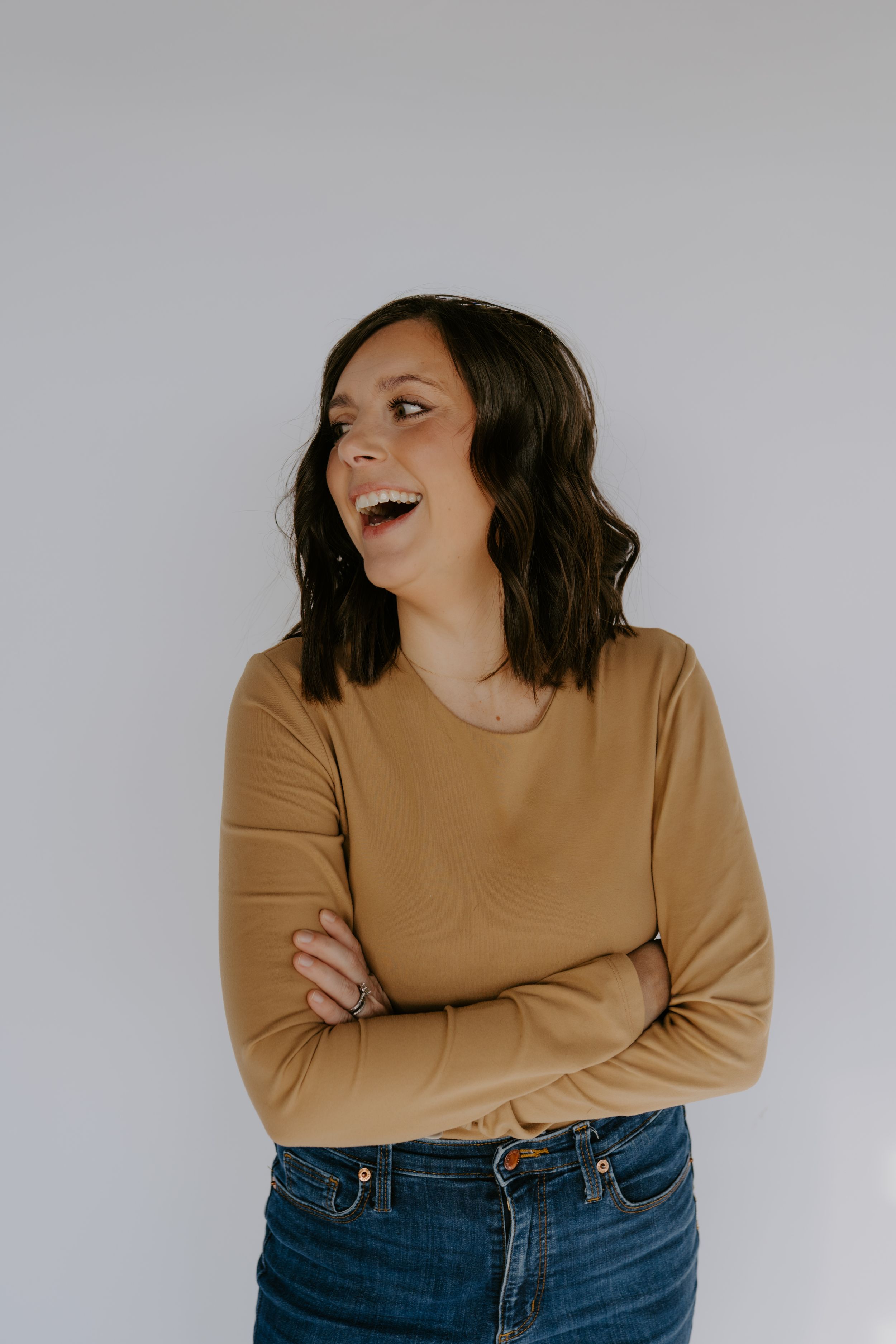 A series of expressive portraits showing a woman in a tan sweater against a light gray backdrop.
