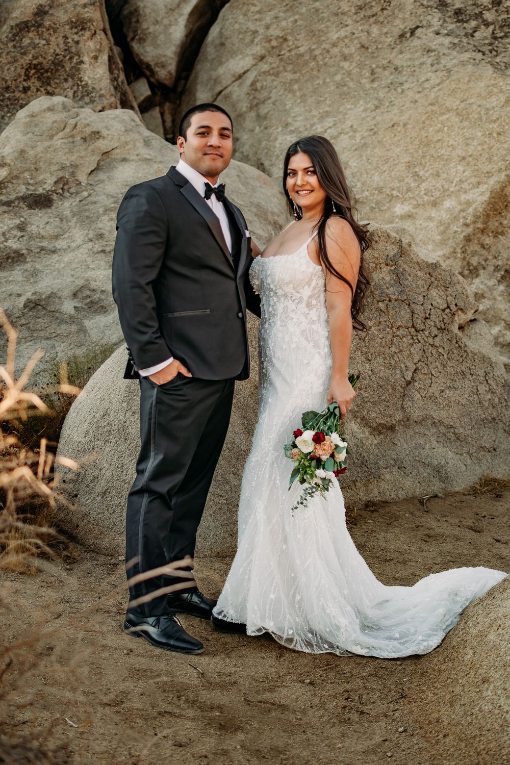 Elegant wedding portraits against rocky backdrop showcase romantic poses and bridal bouquet.