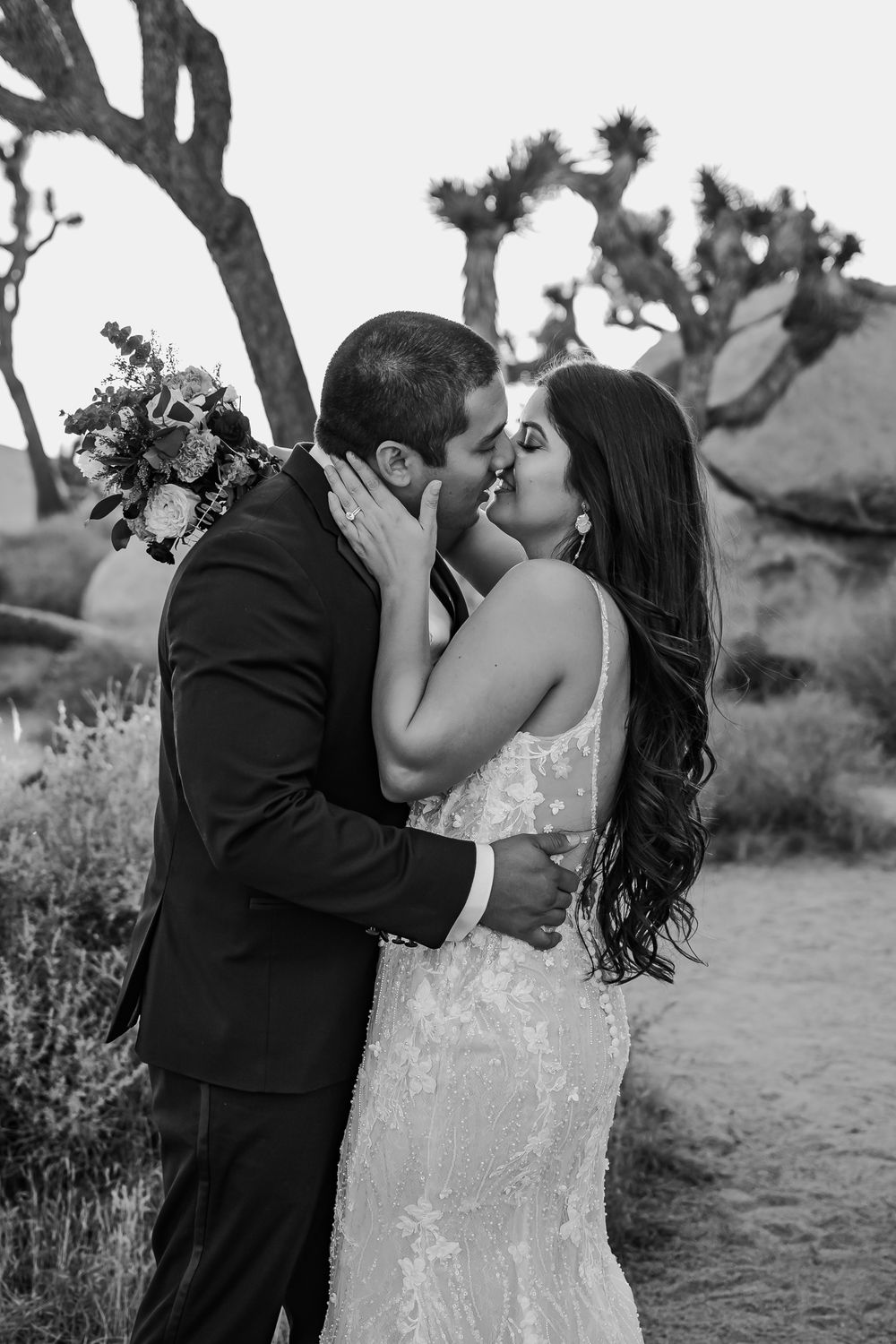 Black and white wedding portraits captured in a desert landscape.
