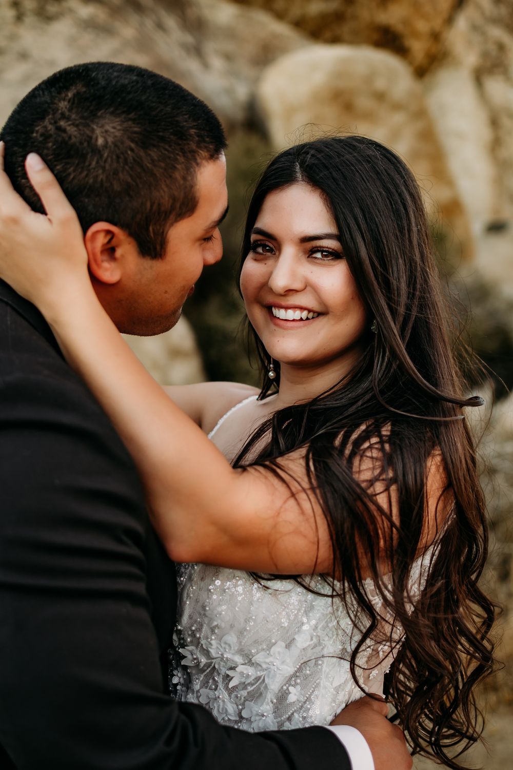 Joyful wedding couple shares candid moment during outdoor photo session.