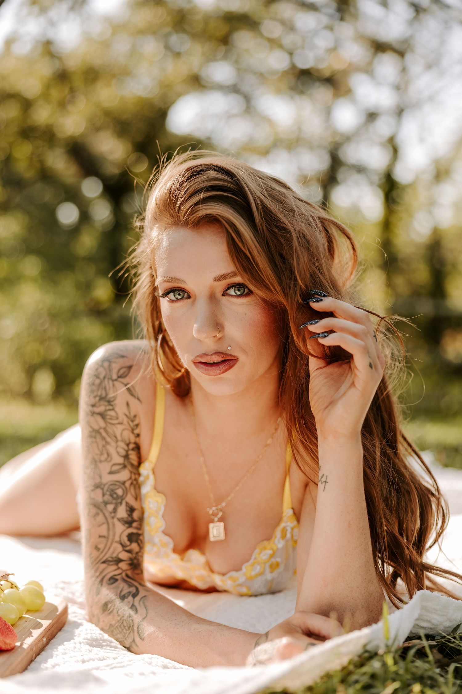 Outdoor boudoir photography session with soft natural lighting and bokeh effect.