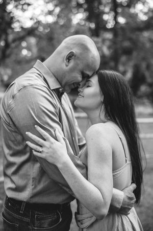 A black and white series of romantic moments between a couple in a park setting.