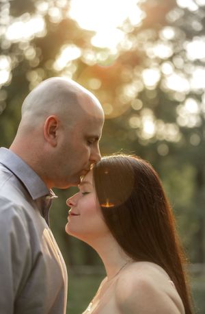 A couple shares a romantic moment in golden hour lighting with beautiful bokeh effects.