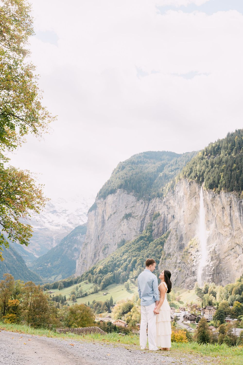 Scenic mountain landscape in Switzerland's Lauterbrunnen Valley with towering cliffs and green meadows in summer.