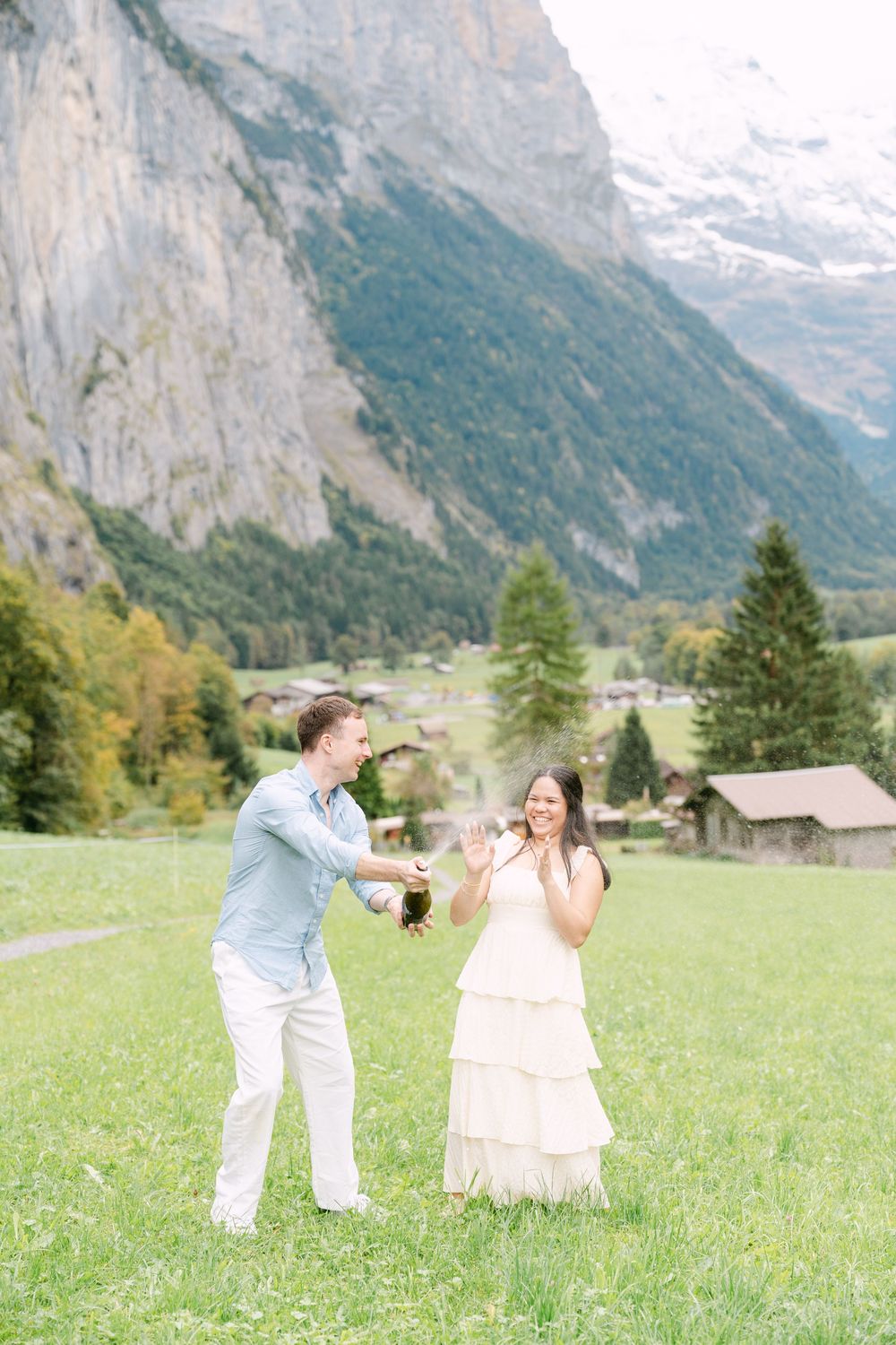 A playful scene in a Swiss Alpine meadow with snow-capped mountains and traditional buildings in the distance in Lauterbrunnen.