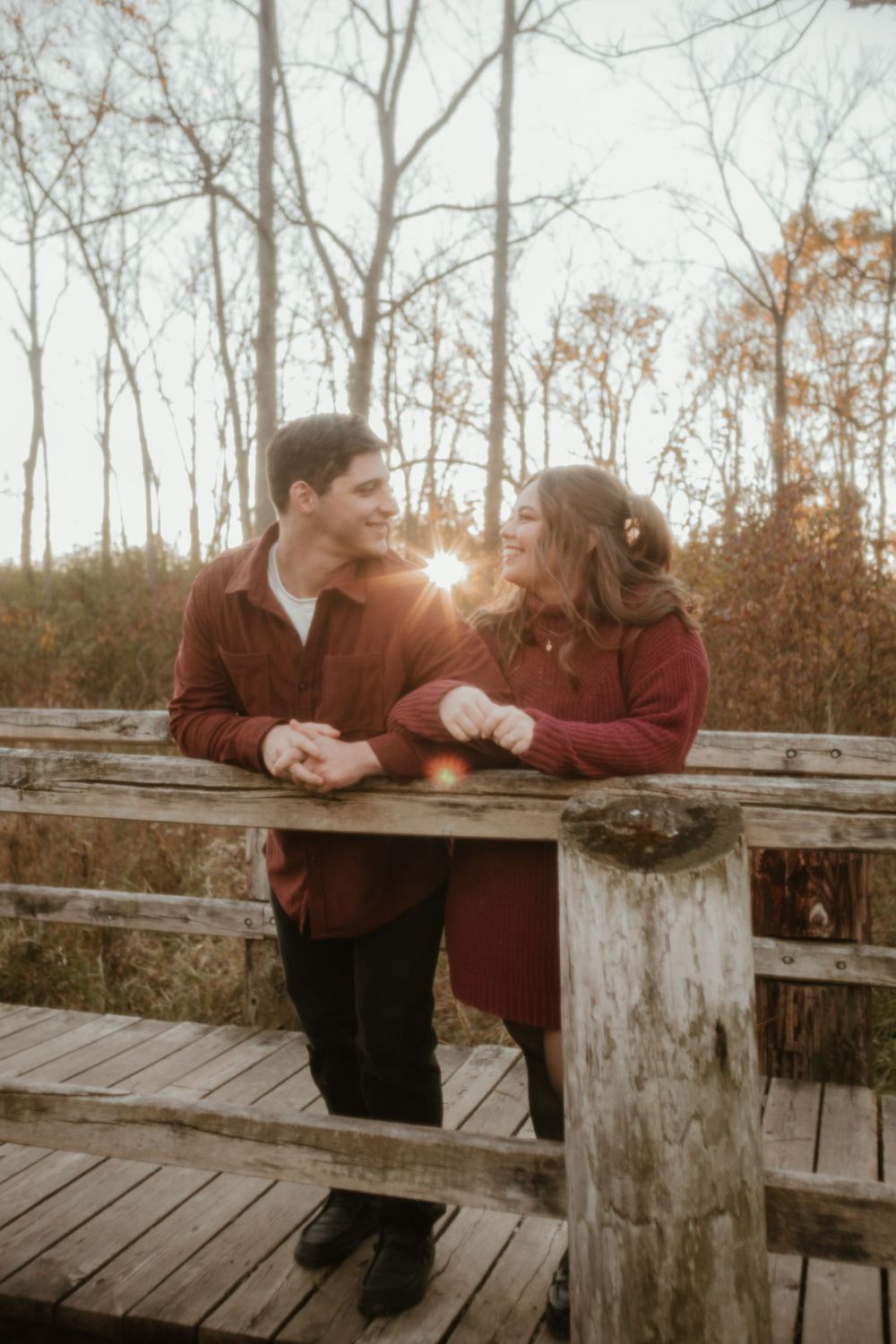 A romantic autumn scene on a wooden deck with sunlight streaming through bare trees in the background.