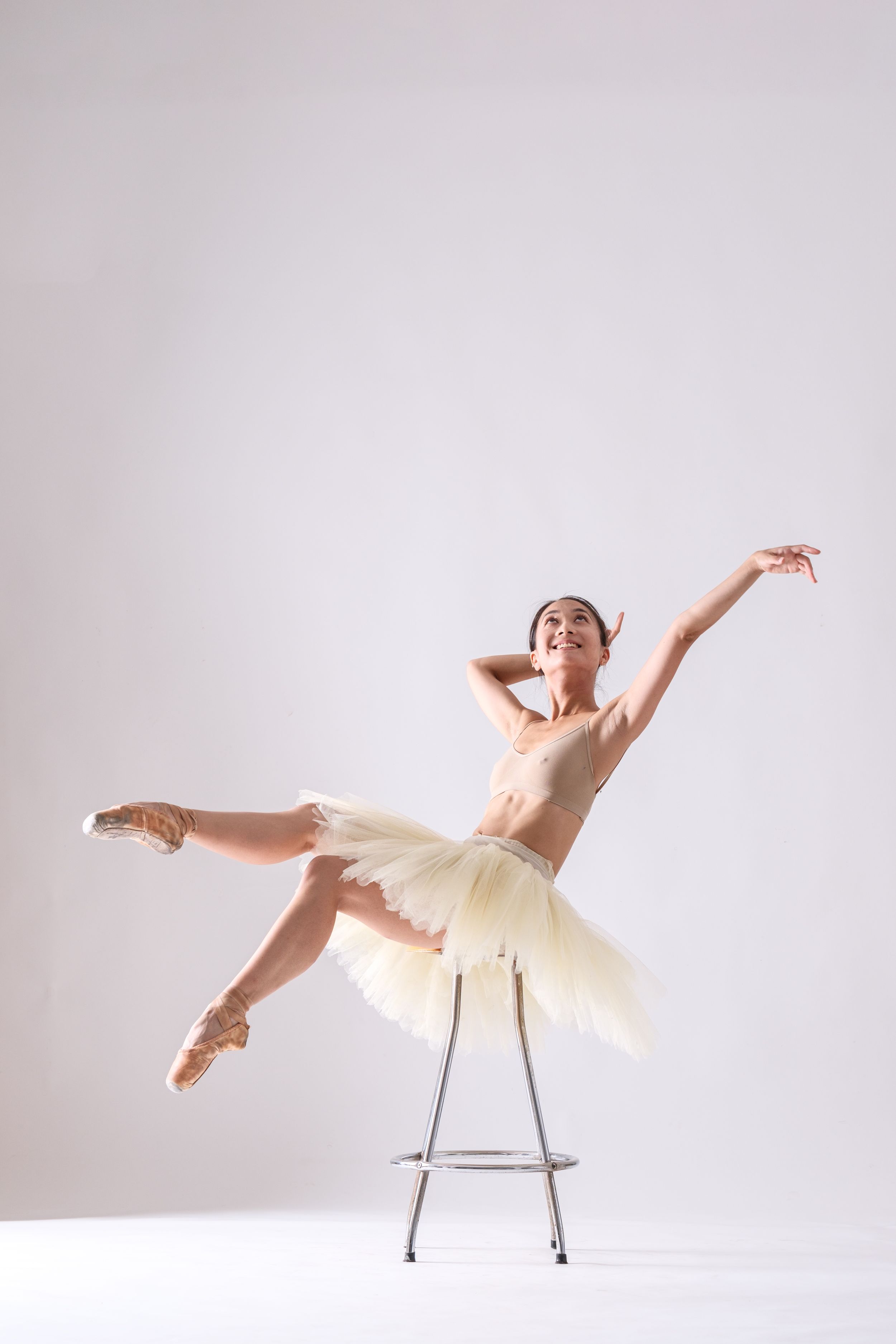 Artistic dance sequence showing flowing movements with chair prop in white studio space.