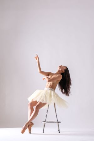 Expressive dance sequence showing graceful movements with chair against simple white background.