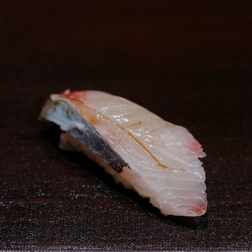 White fish sushi nigiri with delicate scoring on top.
