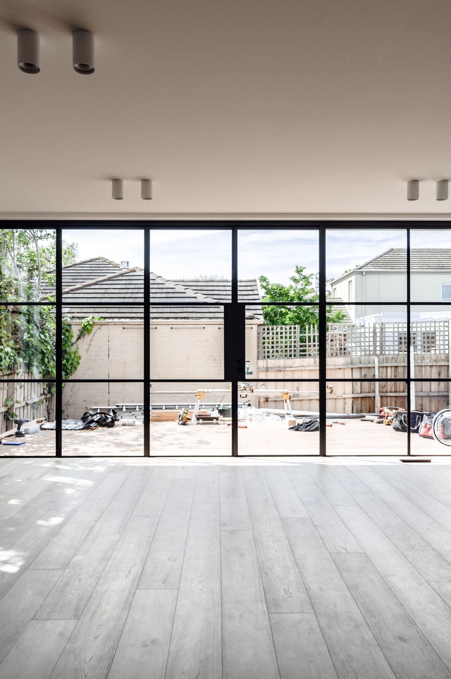 Floor-to-ceiling windows with modern lighting fixtures and gray flooring in contemporary space.