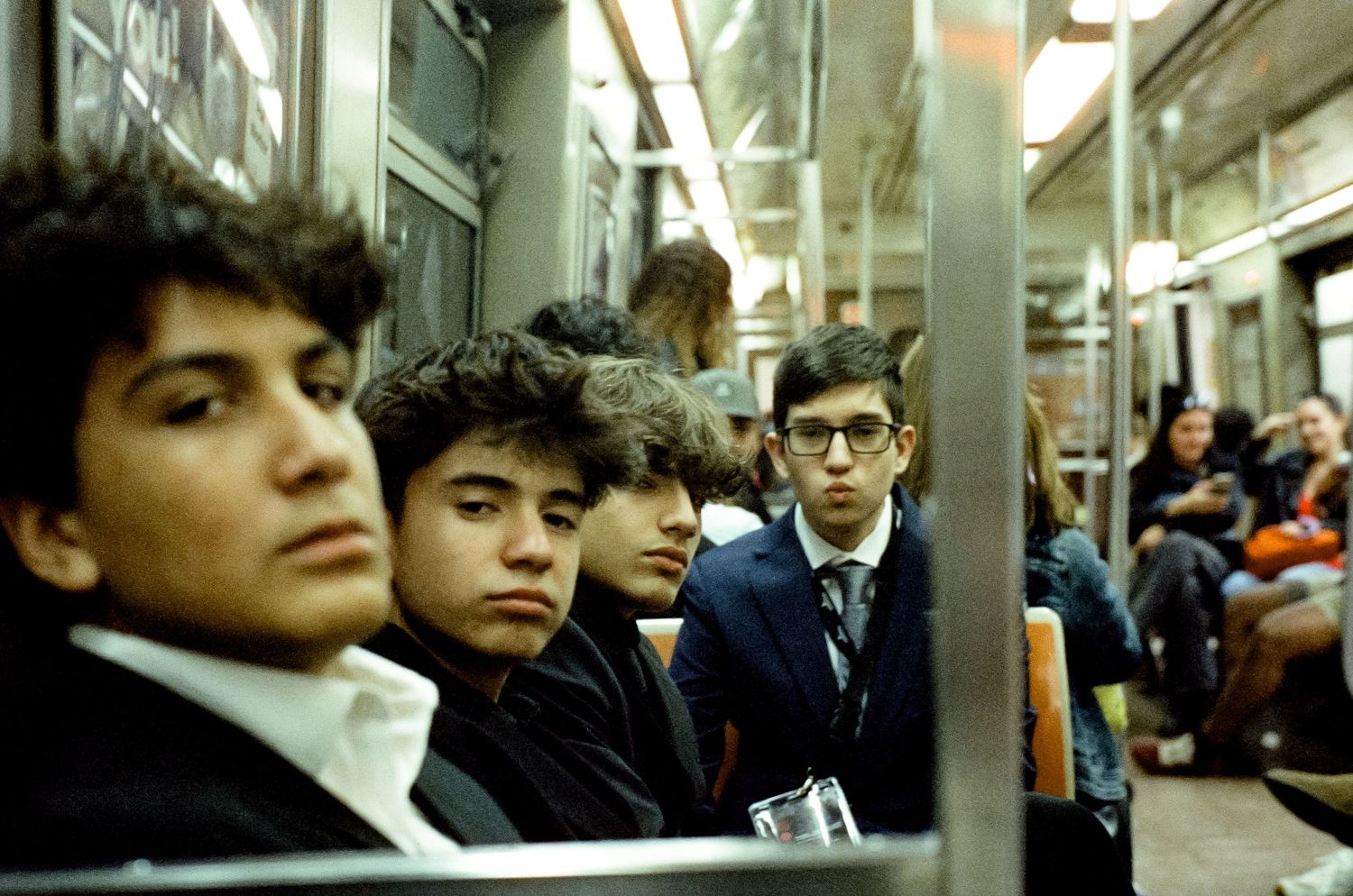 Passengers sitting in a dimly lit subway car during a commute.