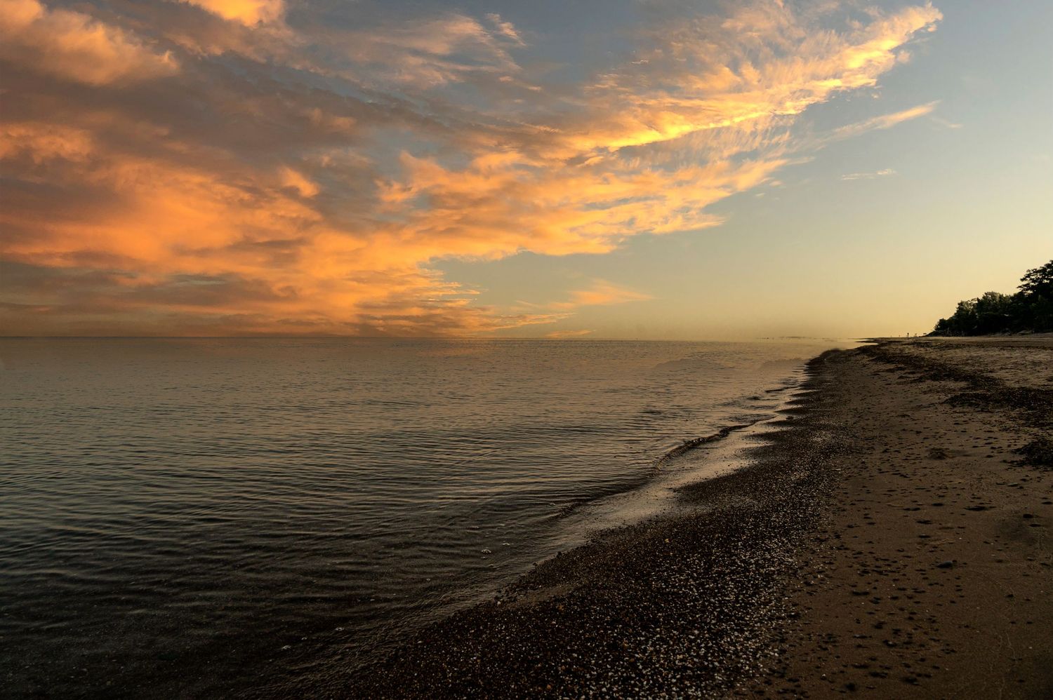 Panoramic series of sunset views over a beach coastline with dramatic orange clouds reflecting on the ocean surface.
