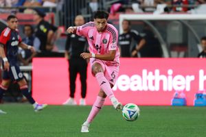 Soccer players chase after loose ball during professional match.