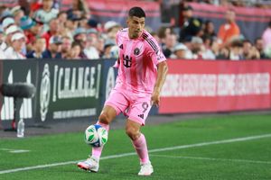 Soccer players compete for control during match on professional pitch.